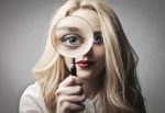 12802027 – beautiful woman holding a magnifying glass